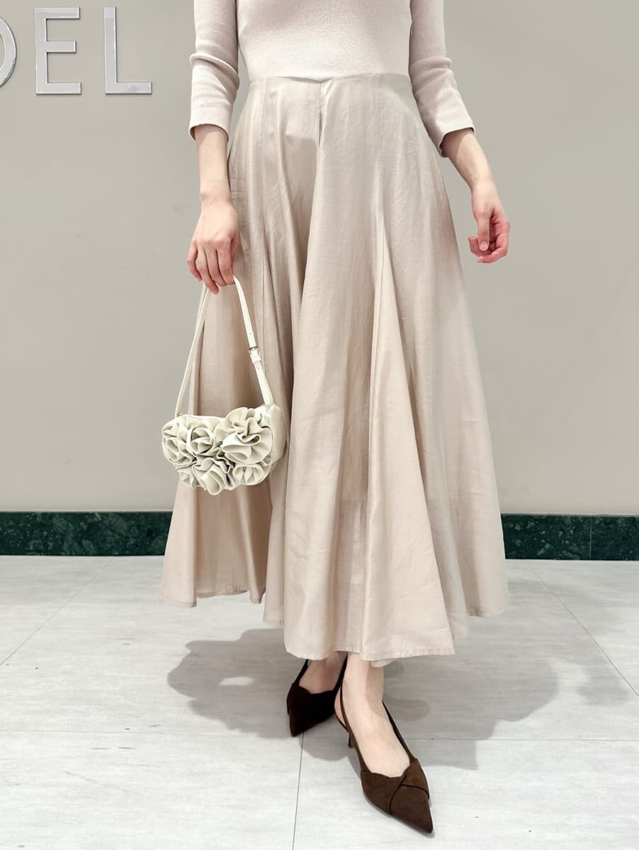 ブラウン系のパンプス、ホワイト系のハンドバッグを着用したレディースの冬コーディネートの3枚目の写真