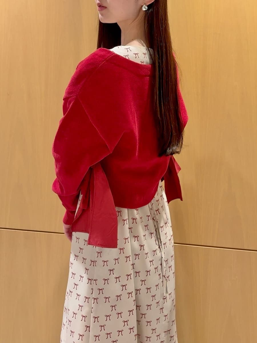 ホワイト系のハンドバッグ、ベージュ系のワンピース、レッド系のカーディガン/ボレロを着用したレディースの冬コーディネートの6枚目の写真