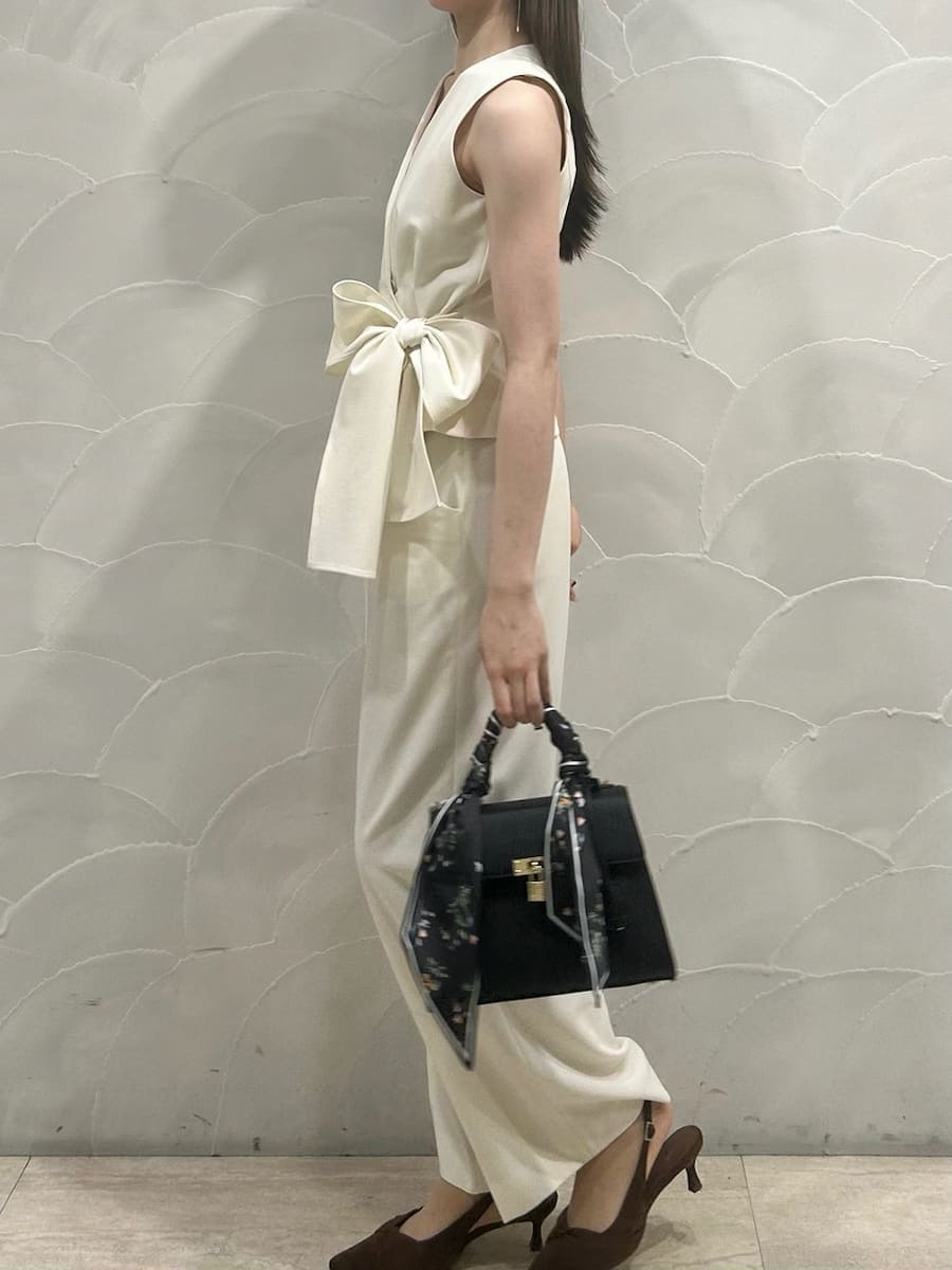 ホワイト系のテーラードジャケット、ホワイト系のスラックス、ブラウン系のパンプスを着用したレディースの冬コーディネートの5枚目の写真