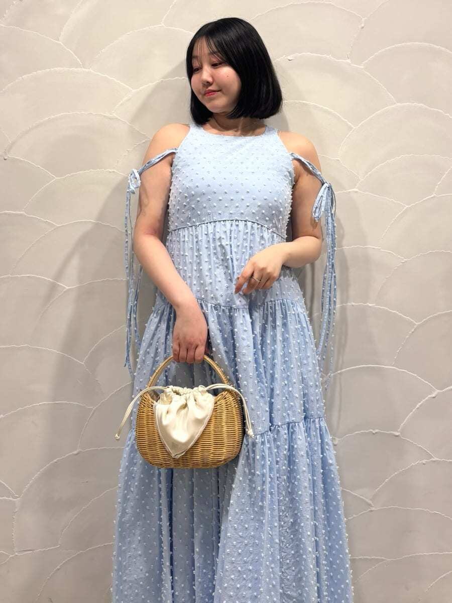 ホワイト系のかごバッグ、ブルー系のワンピース、ホワイト系のカーディガン/ボレロを着用したレディースの春コーディネートの7枚目の写真