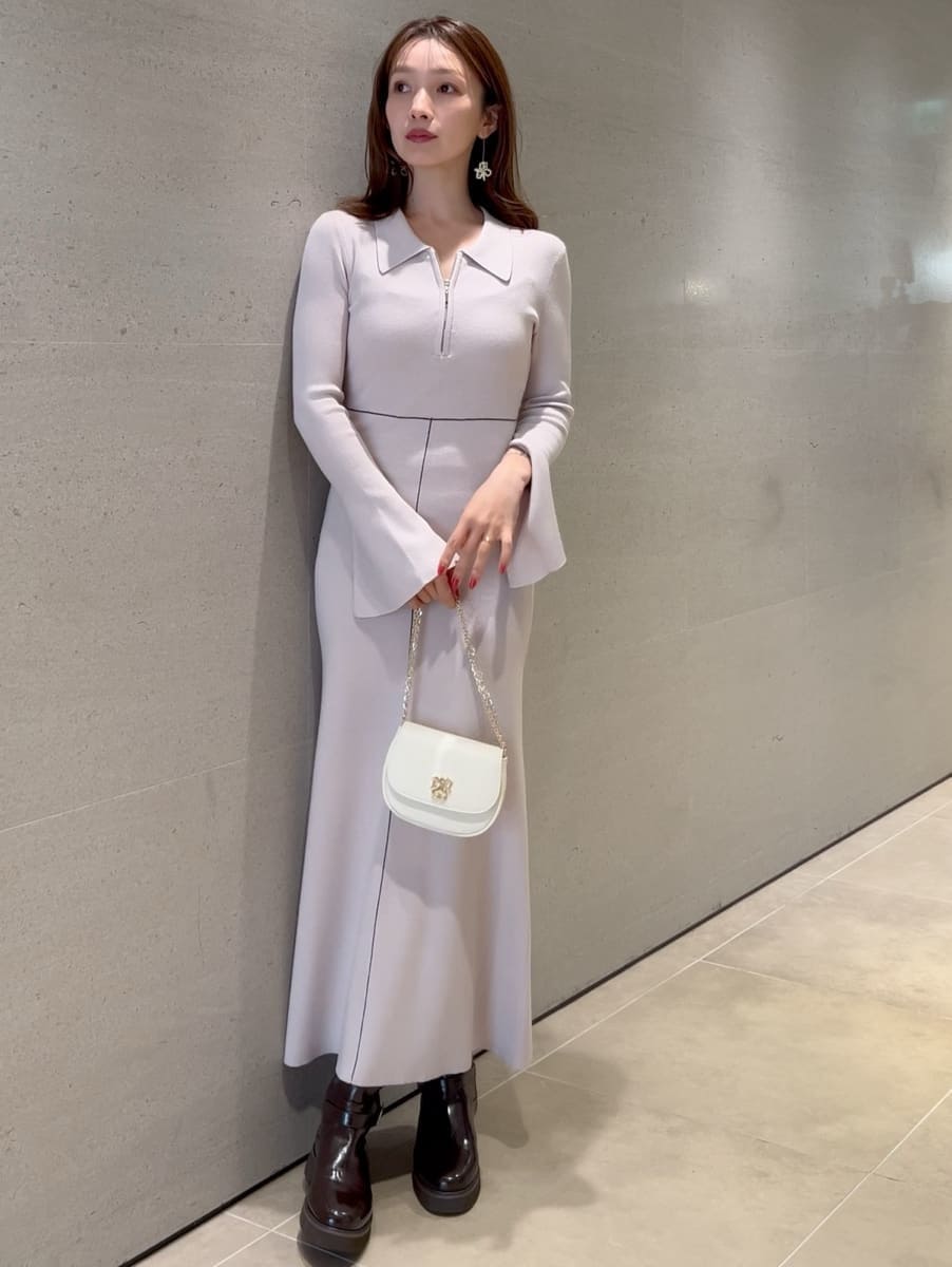 ホワイト系のワンピース、グリーン系のトレンチコート、ホワイト系のショルダーバッグを着用したレディースの冬コーディネートの2枚目の写真