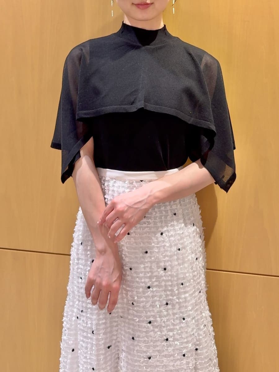 ブラック系のパンプス、ブラック系のハンドバッグ、その他のイヤリングを着用したレディースの春コーディネートの4枚目の写真