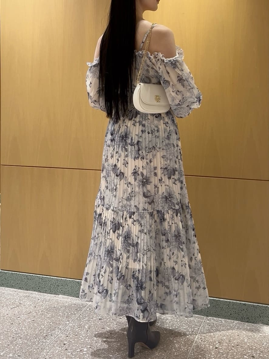 グレー系のブーツ、イエロー系のワンピース、ホワイト系のショルダーバッグを着用したレディースの冬コーディネートの6枚目の写真