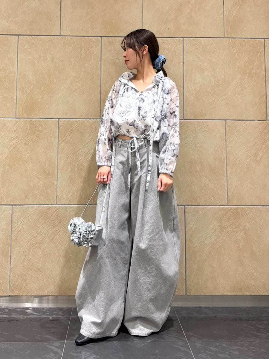 グレー系のデニムパンツ、ホワイト系のシャツ/ブラウス、シルバー系のハンドバッグを着用したレディースの冬コーディネートの2枚目の写真