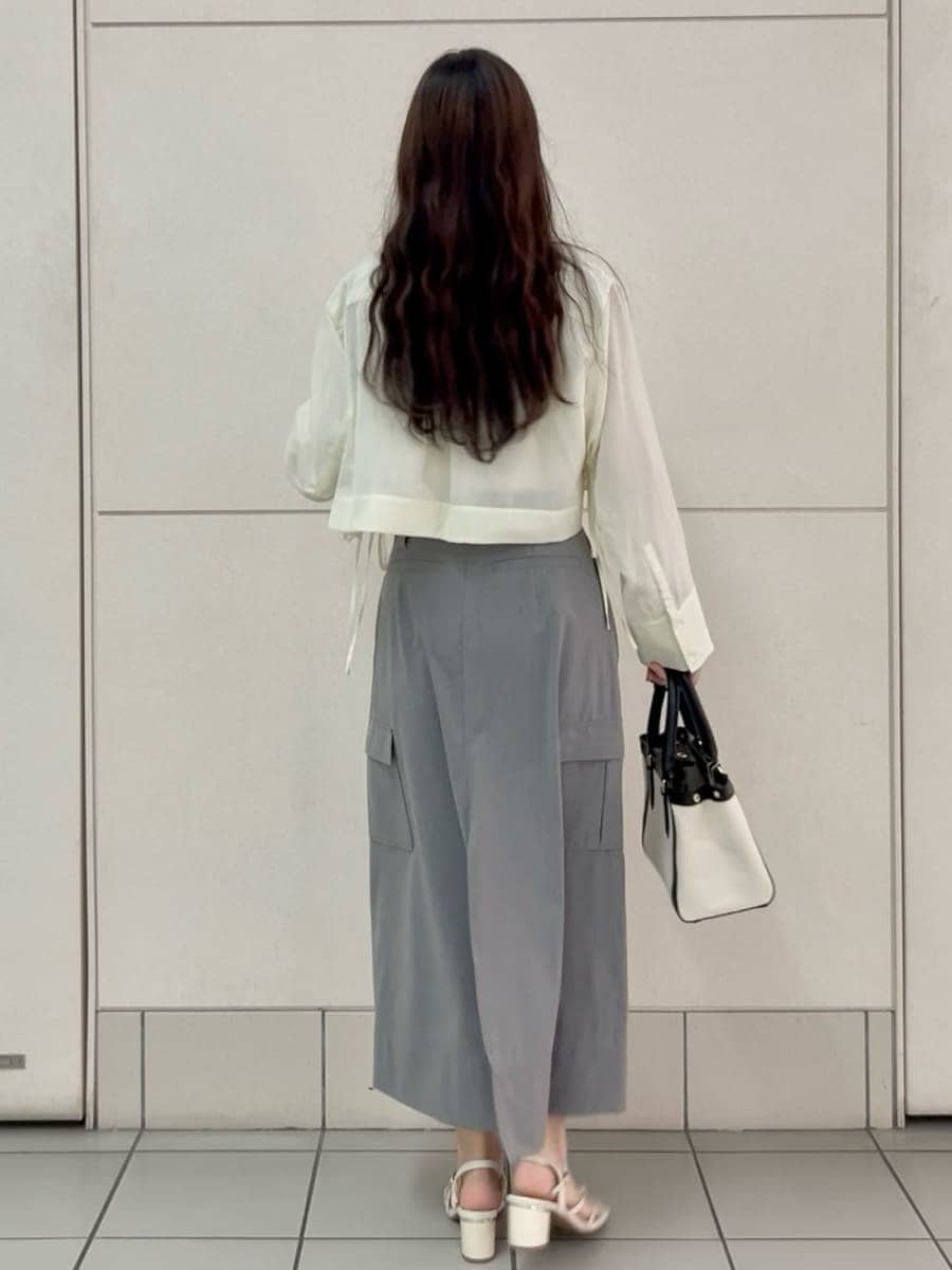 グレー系のスカート、ホワイト系のシャツ/ブラウス、ブラック系のハンドバッグを着用したレディースの夏コーディネートの4枚目の写真