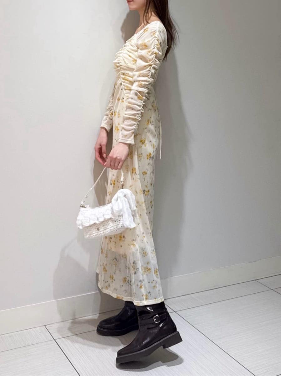 ブラウン系のブーツ、ホワイト系のブルゾン、イエロー系のワンピースを着用したレディースの冬コーディネートの4枚目の写真