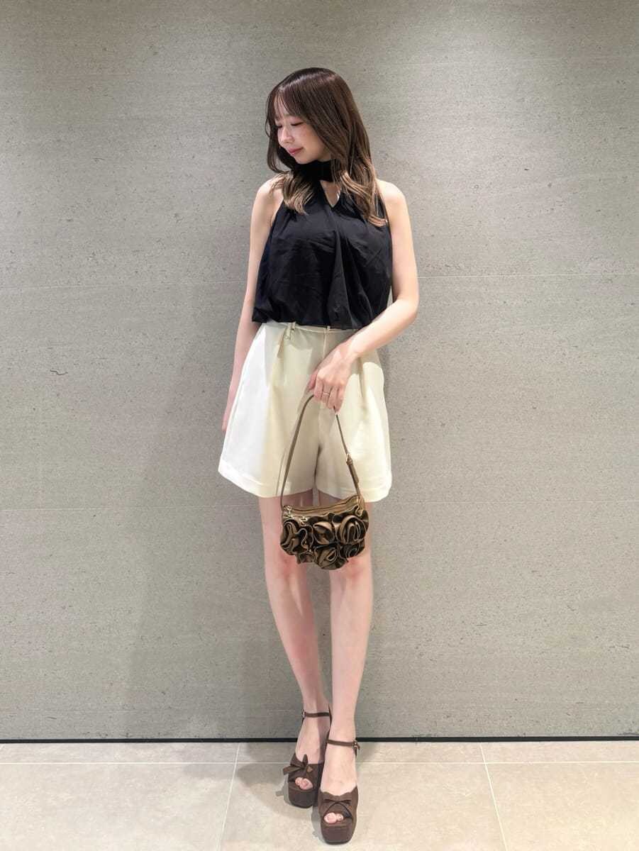 ブラウン系のハンドバッグ、ホワイト系のその他パンツ、ブラック系のTシャツ/カットソーを着用したレディースの夏コーディネートの3枚目の写真