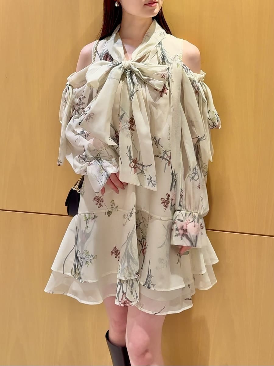 イエロー系のワンピース、ブラック系のショルダーバッグ、シルバー系のピアス（両耳用）を着用したレディースの冬コーディネートの5枚目の写真