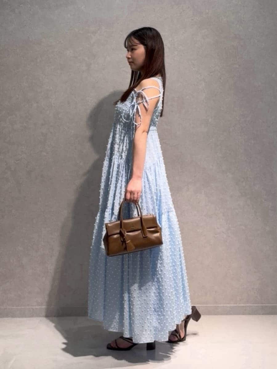 ブルー系のワンピース、ブラウン系のサンダル、ブラウン系のボストンバッグを着用したレディースの夏コーディネートの2枚目の写真
