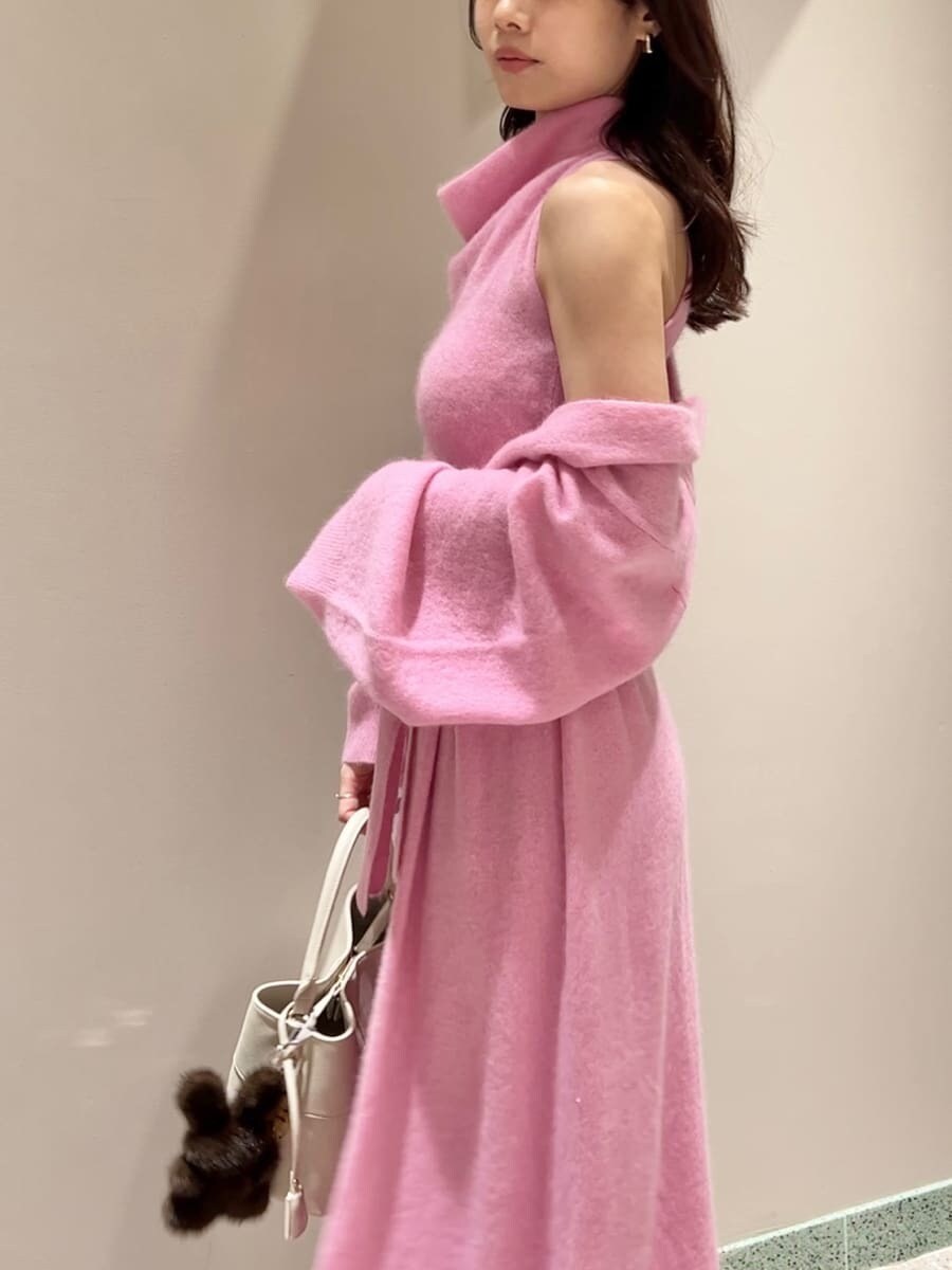 レッド系のブーツ、ピンク系のチェスターコート、ピンク系のワンピースを着用したレディースの冬コーディネートの6枚目の写真