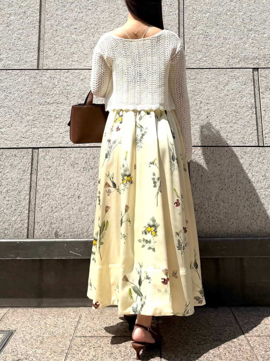 イエロー系のワンピース、ホワイト系のカーディガン/ボレロ、ブラウン系のパンプスを着用したレディースの春コーディネートの4枚目の写真