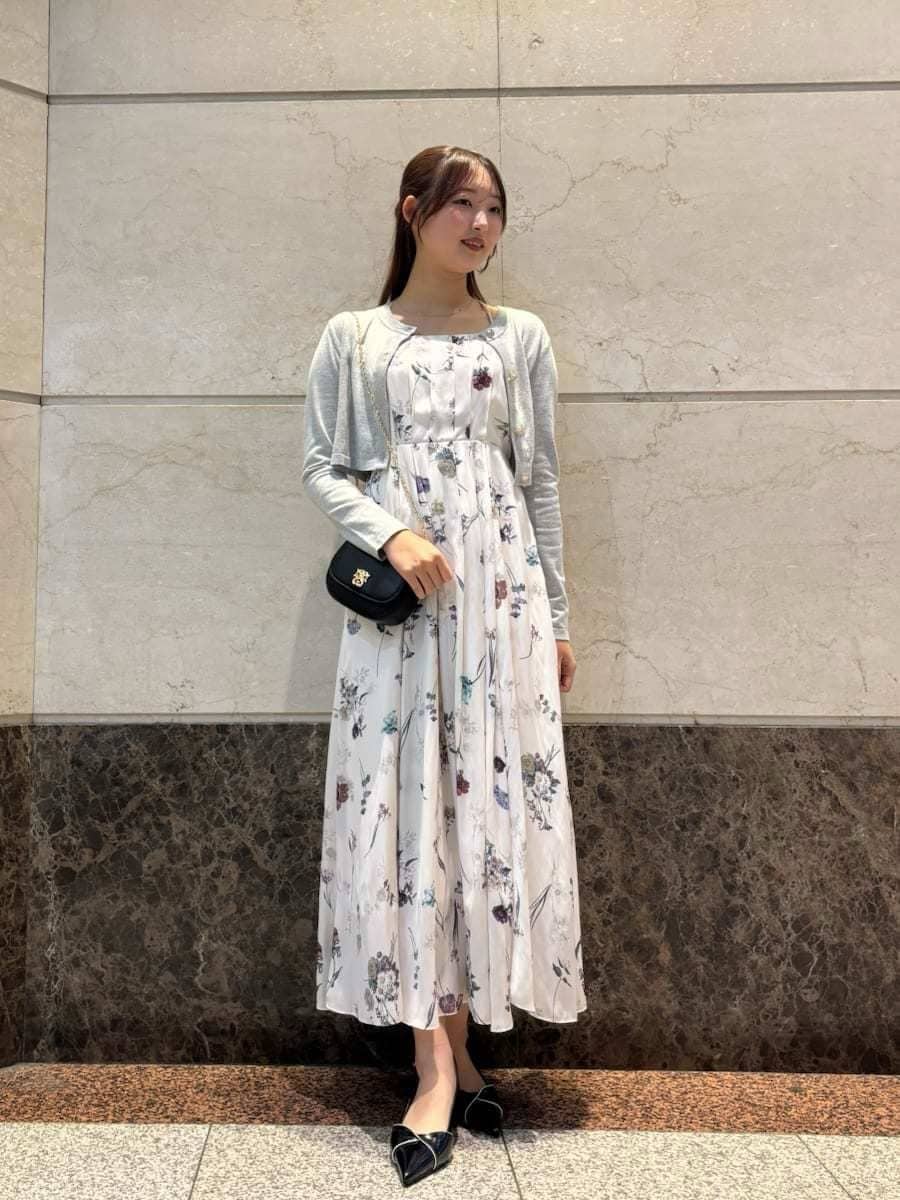 ホワイト系のワンピース、ブラック系のパンプス、ブラック系のショルダーバッグを着用したレディースの冬コーディネートの3枚目の写真