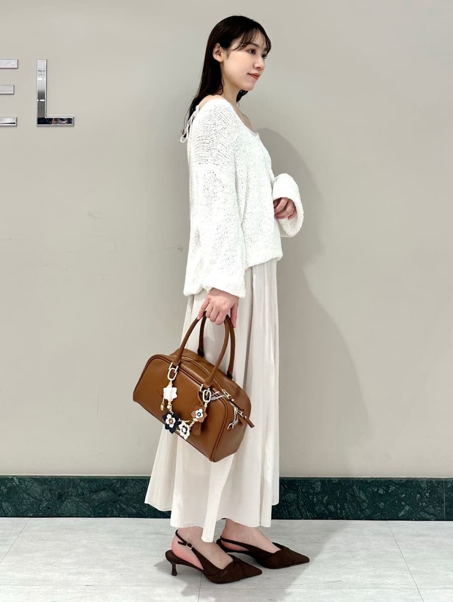 ホワイト系のワンピース、ブラウン系のパンプス、イエロー系のボストンバッグを着用したレディースの春コーディネートの4枚目の写真