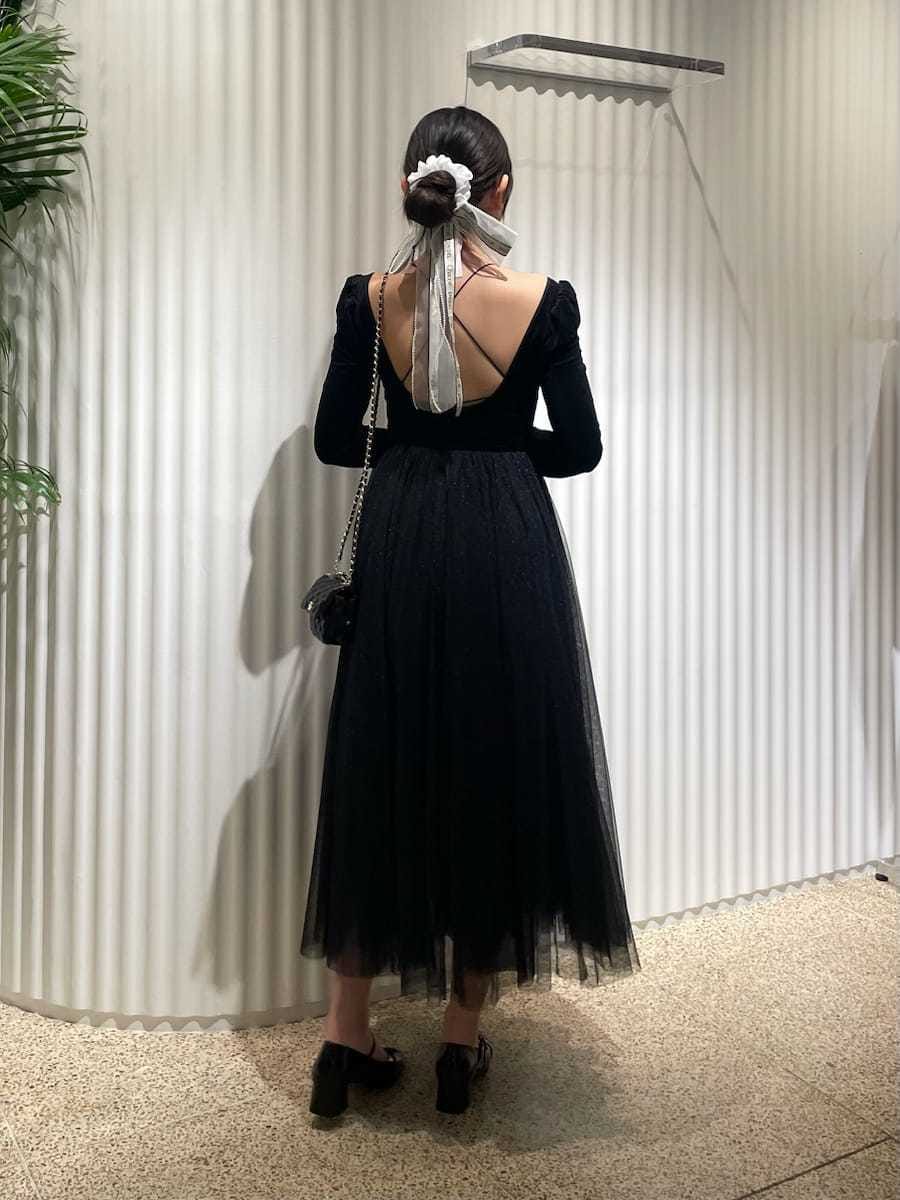 ブラック系のワンピース、ブラック系のパンプス、ブラック系のショルダーバッグを着用したレディースの夏コーディネートの3枚目の写真