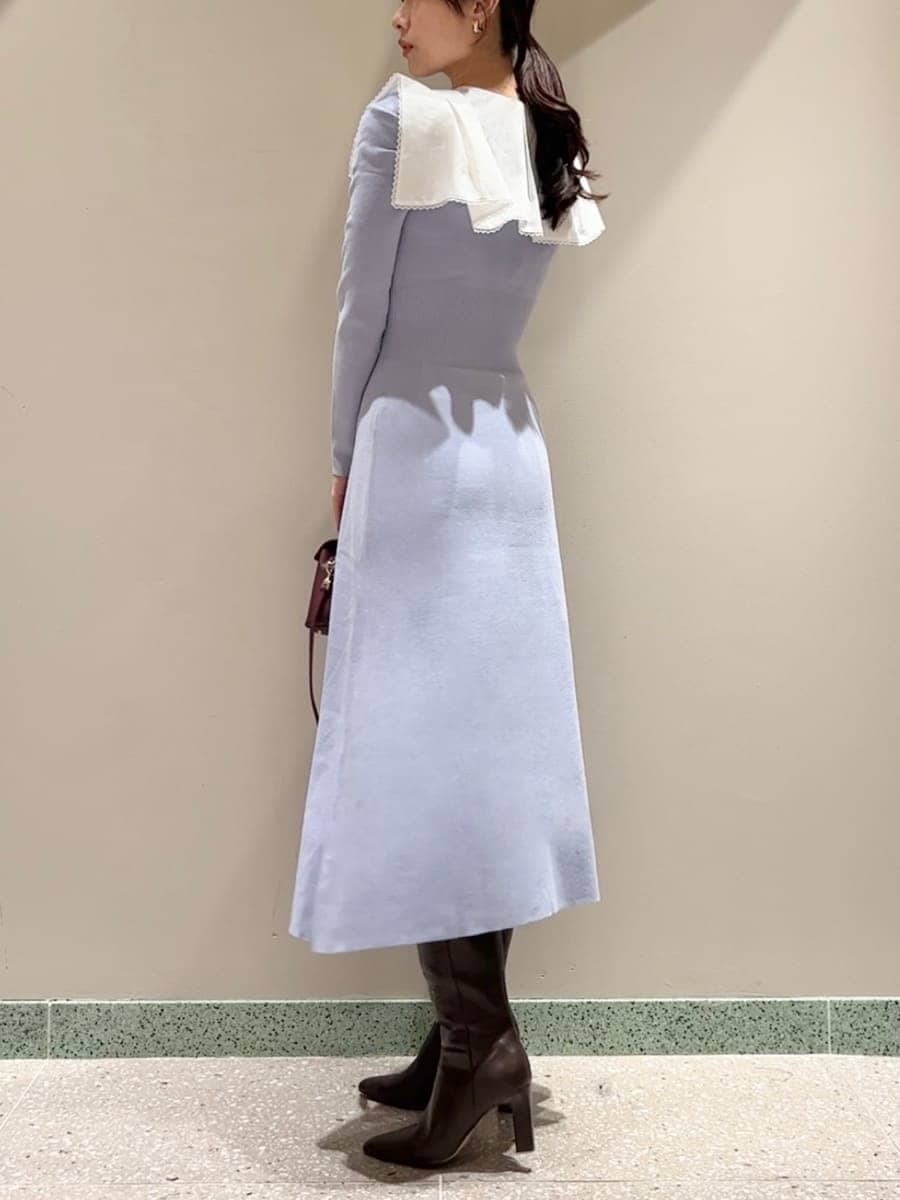 ブラウン系のブーツ、ブラウン系のショルダーバッグ、ブルー系のワンピースを着用したレディースの冬コーディネートの2枚目の写真