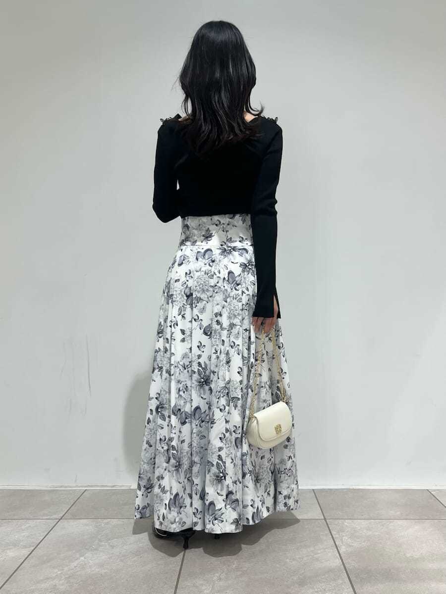 ブラック系のパンプス、ホワイト系のショルダーバッグを着用したレディースの春コーディネートの3枚目の写真