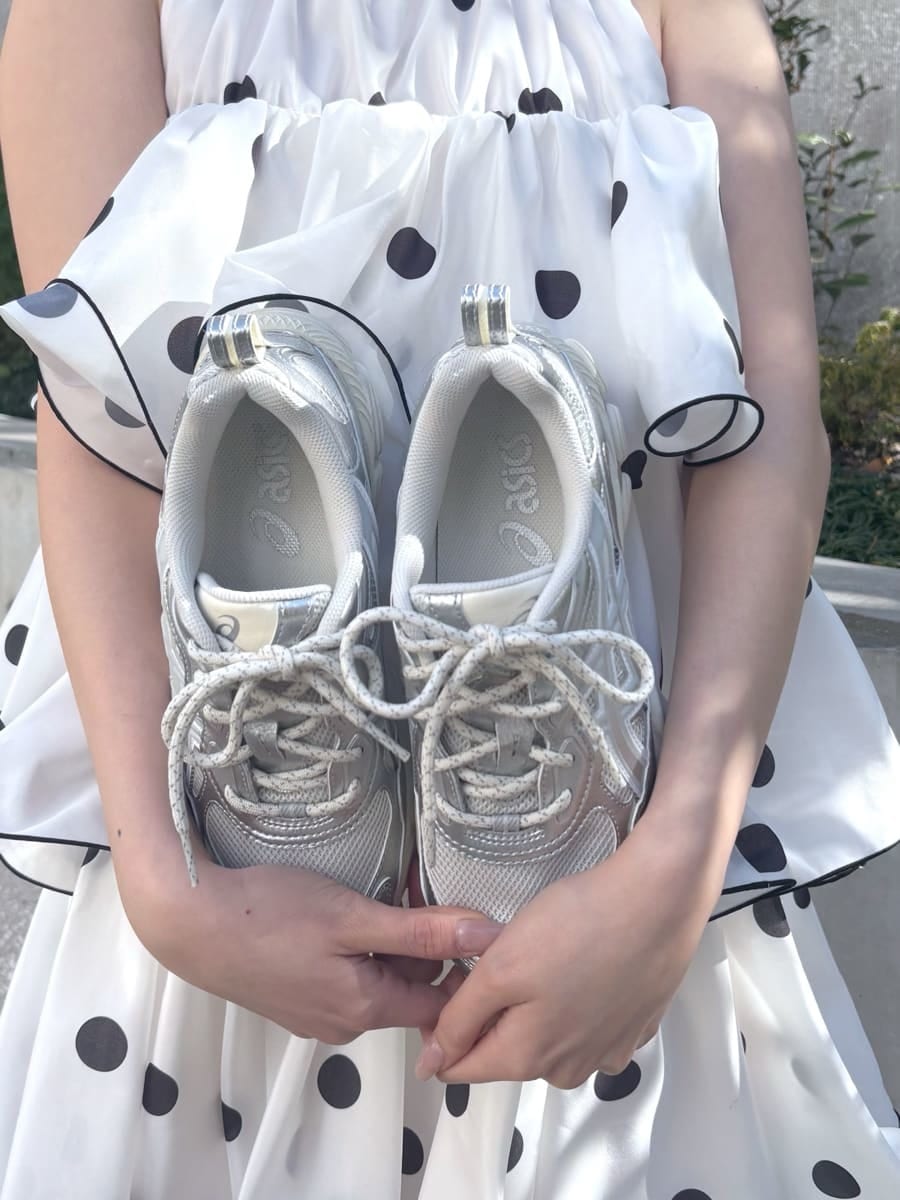 ホワイト系のワンピース、ブラック系のショルダーバッグ、シルバー系のスニーカーを着用したレディースの冬コーディネートの7枚目の写真