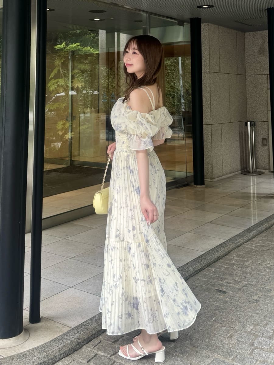 イエロー系のショルダーバッグ、イエロー系のワンピース、ホワイト系のサンダルを着用したレディースの夏コーディネートの3枚目の写真