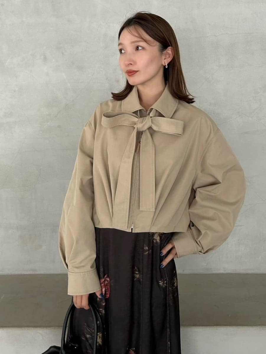 ベージュ系のブルゾン、ブラック系のワンピース、ブラック系のボストンバッグを着用したレディースの冬コーディネートの6枚目の写真