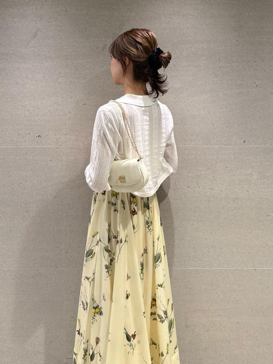 イエロー系のワンピース、ホワイト系のカーディガン/ボレロ、ホワイト系のショルダーバッグを着用したレディースの春コーディネートの4枚目の写真