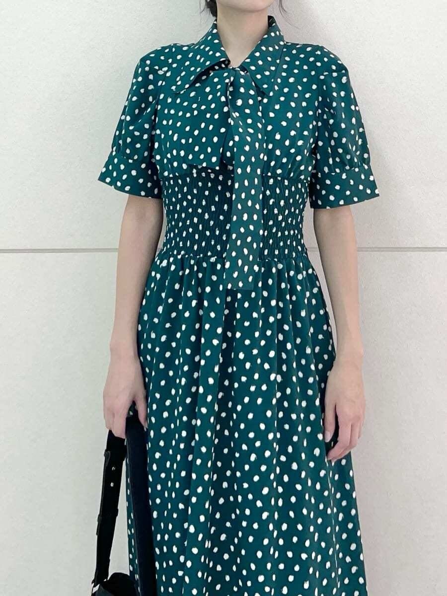 グリーン系のワンピース、ブラック系のトートバッグを着用したレディースの夏コーディネートの5枚目の写真