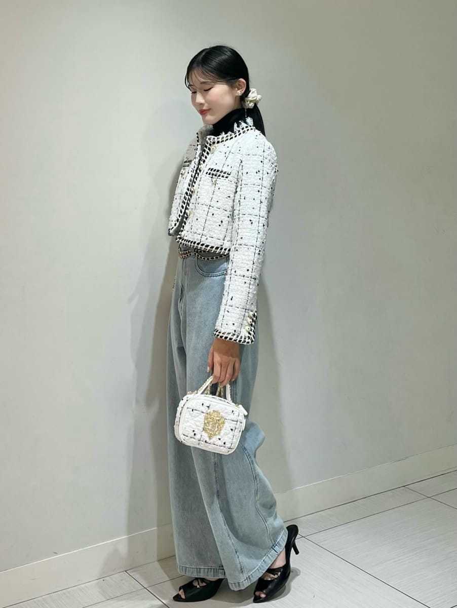 ホワイト系のノーカラージャケット、ブルー系のデニムパンツ、ブラック系のニット/セーターを着用したレディースの秋コーディネートの2枚目の写真