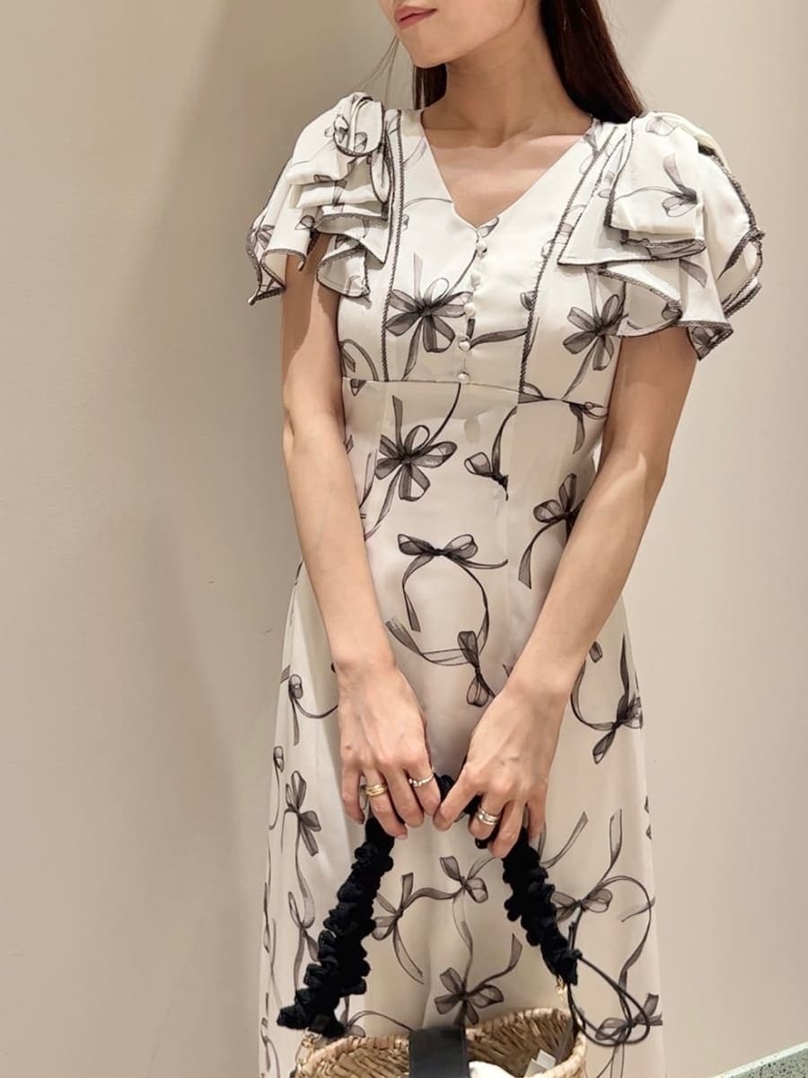 ホワイト系のワンピース、ブラック系のかごバッグ、ホワイト系のサンダルを着用したレディースの夏コーディネートの4枚目の写真