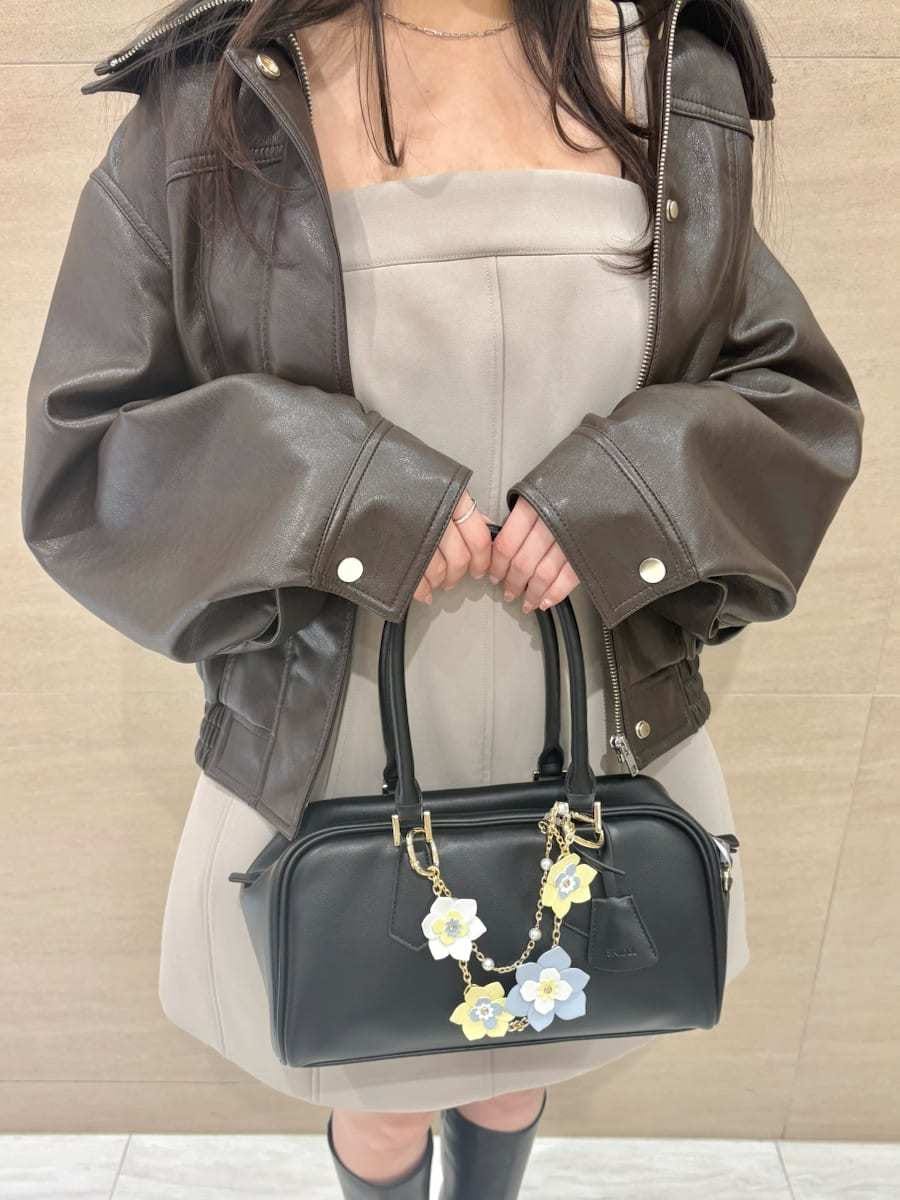 ブラウン系のブルゾン、グリーン系のワンピース、イエロー系のボストンバッグを着用したレディースの冬コーディネートの5枚目の写真