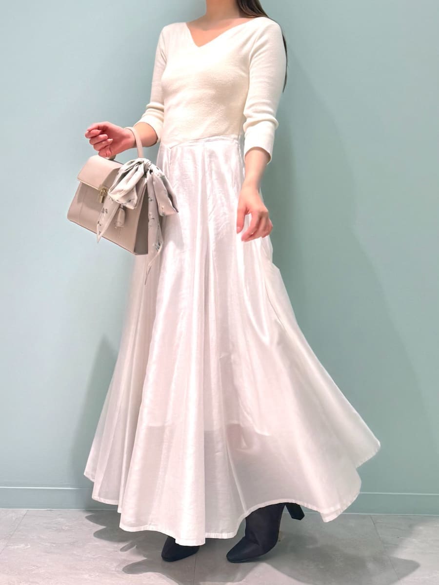 レッド系のブーツ、ベージュ系のトレンチコート、ベージュ系のハンドバッグを着用したレディースの冬コーディネートの4枚目の写真