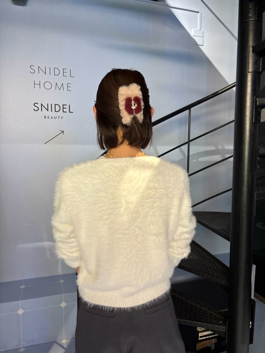 ブラック系のブーツ、ホワイト系のニット/セーター、ブラック系のハンドバッグを着用したレディースの秋コーディネートの6枚目の写真