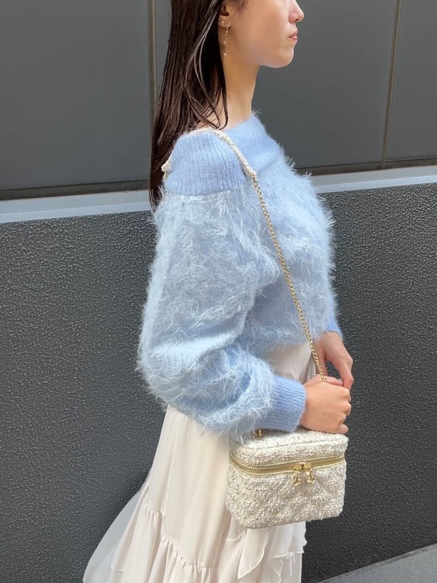 ホワイト系のスカート、ホワイト系のハンドバッグを着用したレディースの冬コーディネートの6枚目の写真