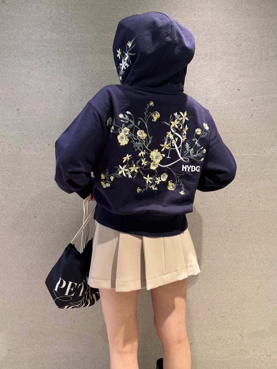 ベージュ系のスカート、ホワイト系のパーカー、ブルー系のバックパック/リュックを着用したレディースの冬コーディネートの5枚目の写真