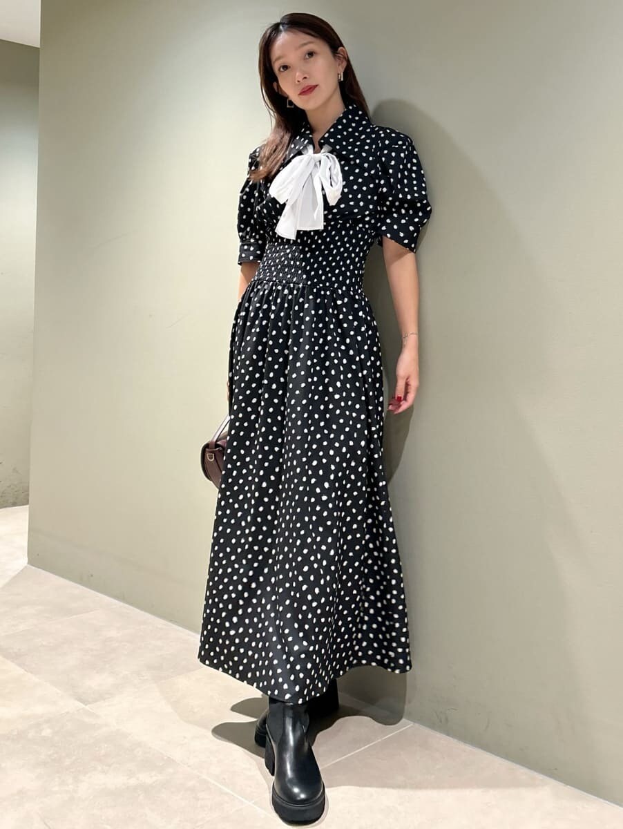 ブラック系のワンピース、ブラウン系のハンドバッグを着用したレディースの秋コーディネートの4枚目の写真