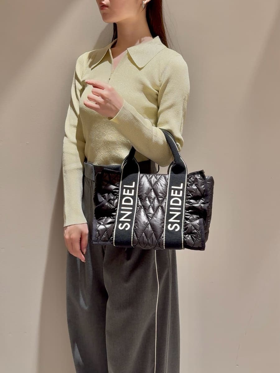 イエロー系のニット/セーター、グレー系のその他パンツ、ブラック系のローファーを着用したレディースの秋コーディネートの5枚目の写真