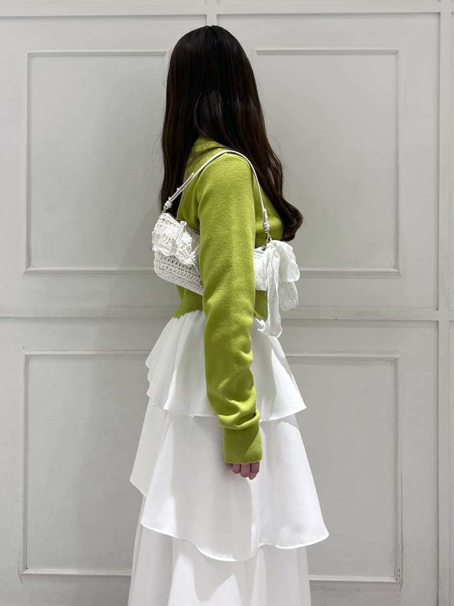 ブラック系のブーツ、イエロー系のワンピース、その他のイヤリングを着用したレディースの冬コーディネートの5枚目の写真