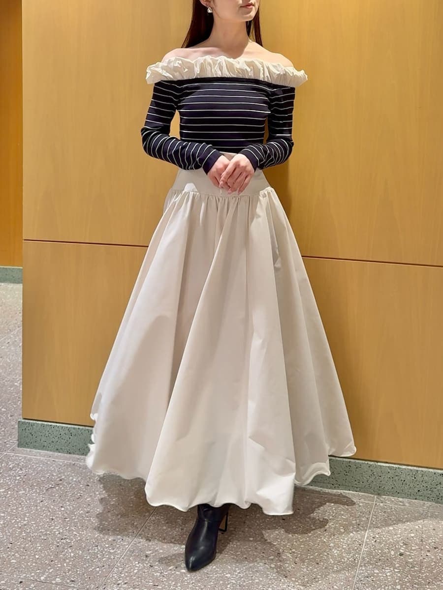 ブラック系のブーツ、ホワイト系のスカート、その他のニット/セーターを着用したレディースの冬コーディネートの7枚目の写真