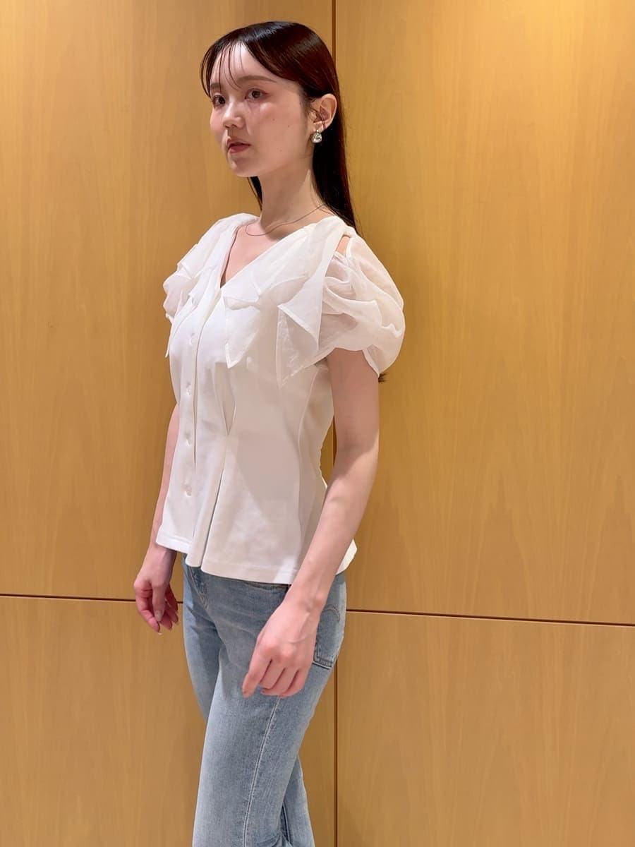 ブルー系のデニムパンツ、ホワイト系のTシャツ/カットソー、ブラウン系のハンドバッグを着用したレディースの夏コーディネートの5枚目の写真