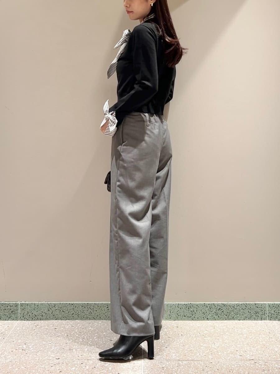 ブラック系のニット/セーター、グレー系のスラックス、ブラック系のショルダーバッグを着用したレディースの秋コーディネートの3枚目の写真