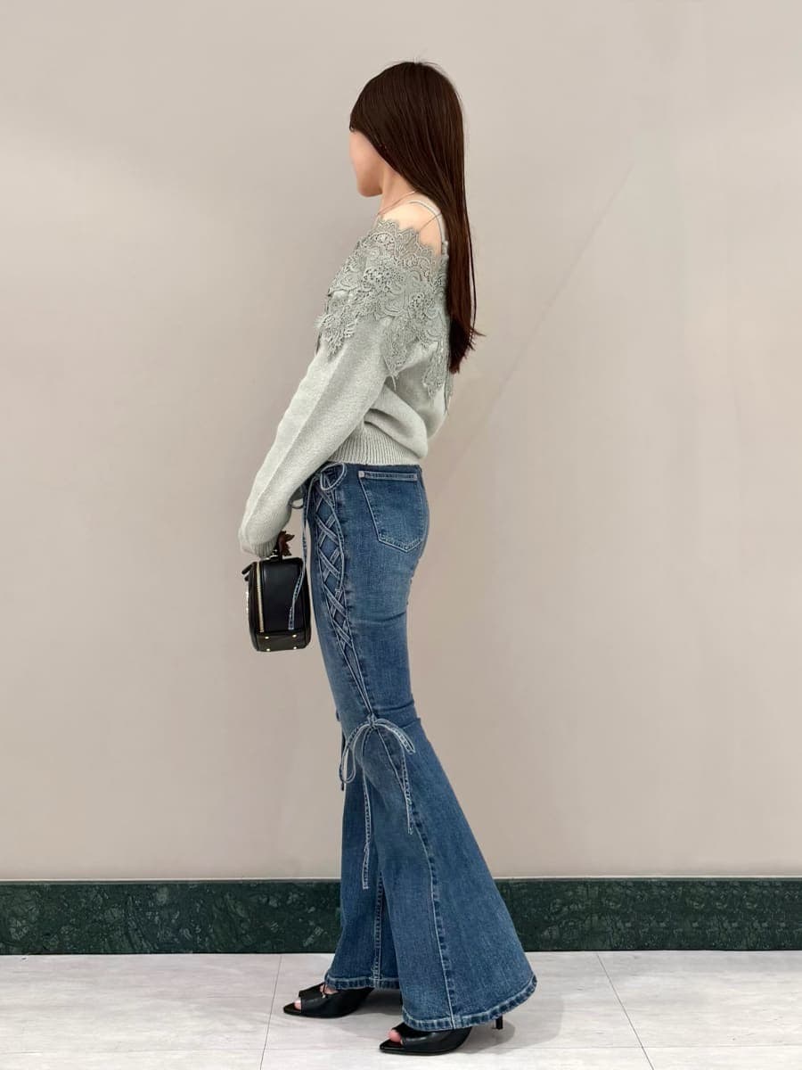 ブルー系のデニムパンツ、グリーン系のニット/セーター、ブラック系のサンダルを着用したレディースの秋コーディネートの2枚目の写真