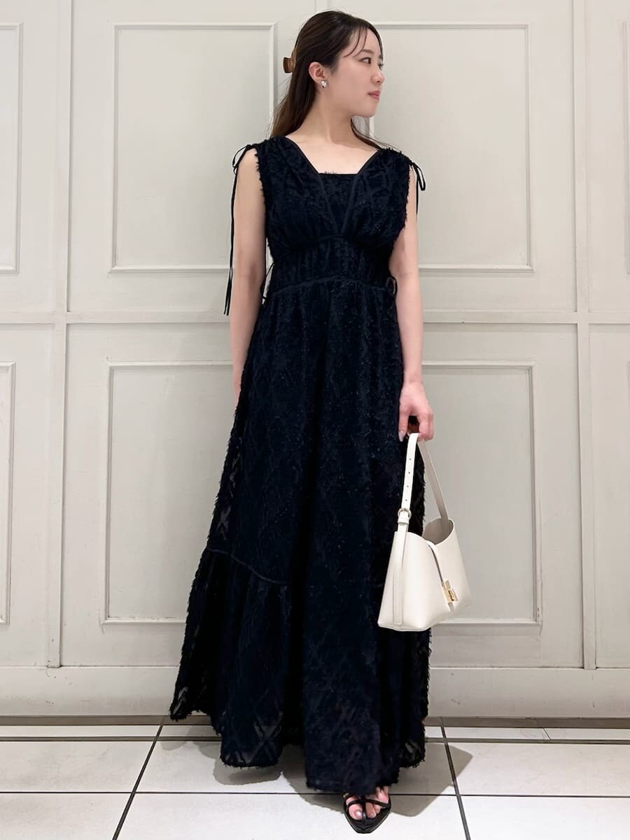 ブルー系のワンピース、ホワイト系のハンドバッグ、ブラック系のサンダルを着用したレディースの夏コーディネートの3枚目の写真