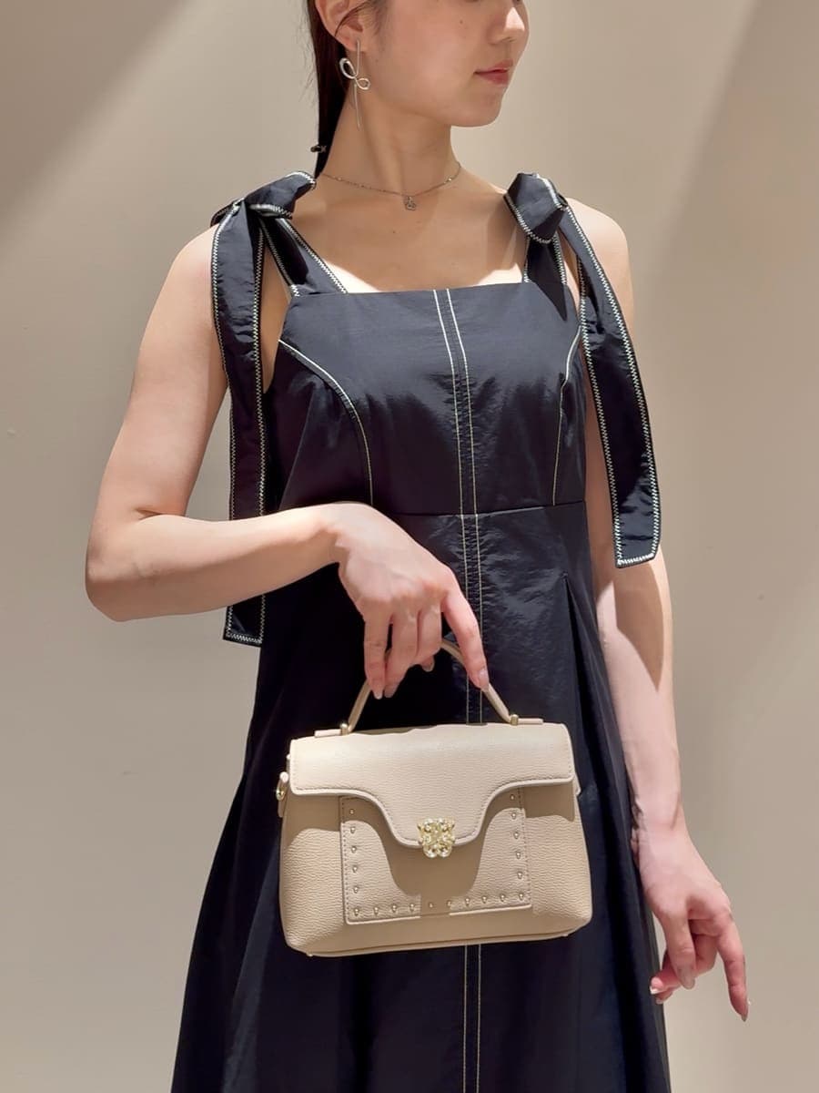 ブラック系のワンピース、ベージュ系のショルダーバッグ、シルバー系のネックレスを着用したレディースの夏コーディネートの6枚目の写真