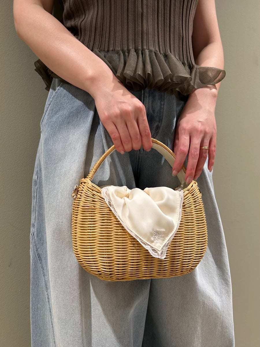 ホワイト系のかごバッグ、ブルー系のデニムパンツ、グリーン系のニット/セーターを着用したレディースの夏コーディネートの5枚目の写真
