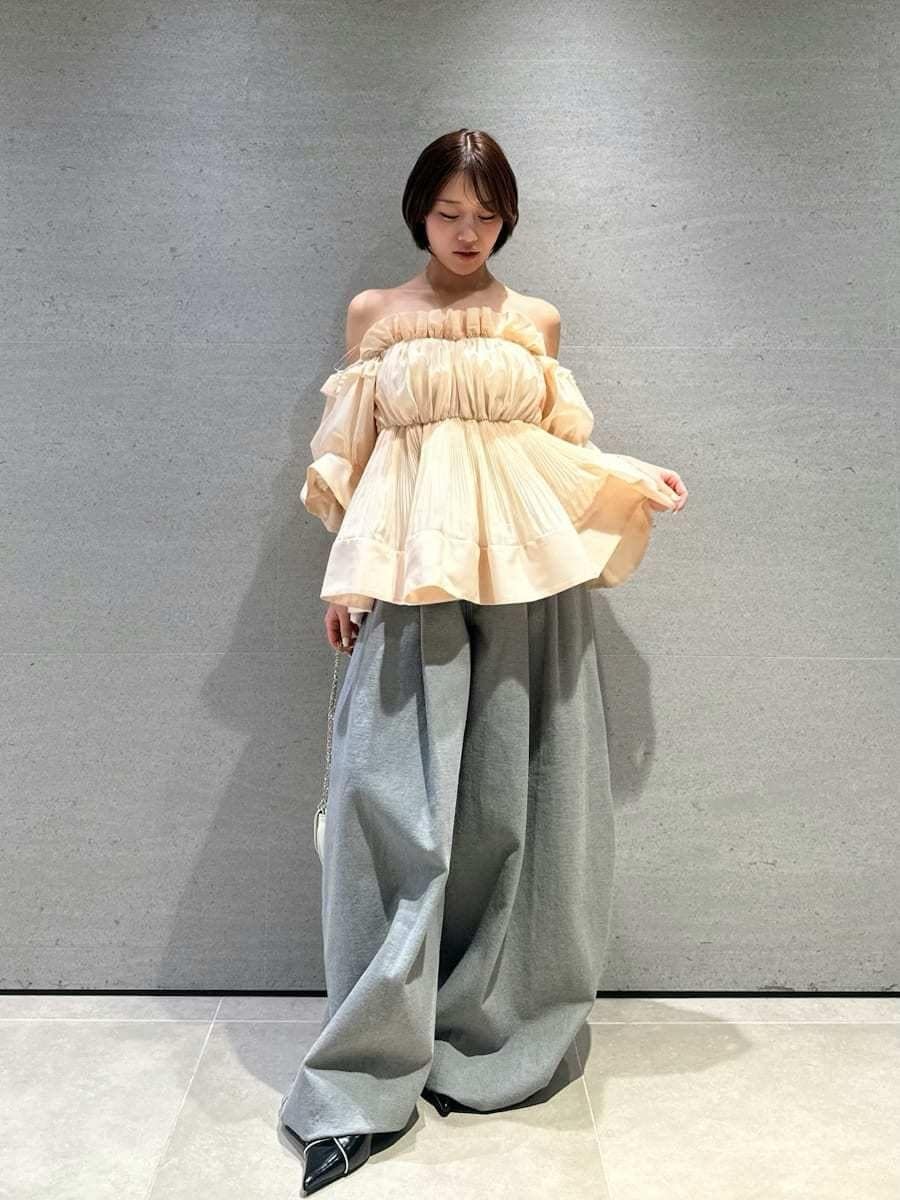 グレー系のデニムパンツ、オレンジ系のその他トップス、ブラック系のパンプスを着用したレディースの春コーディネートの4枚目の写真