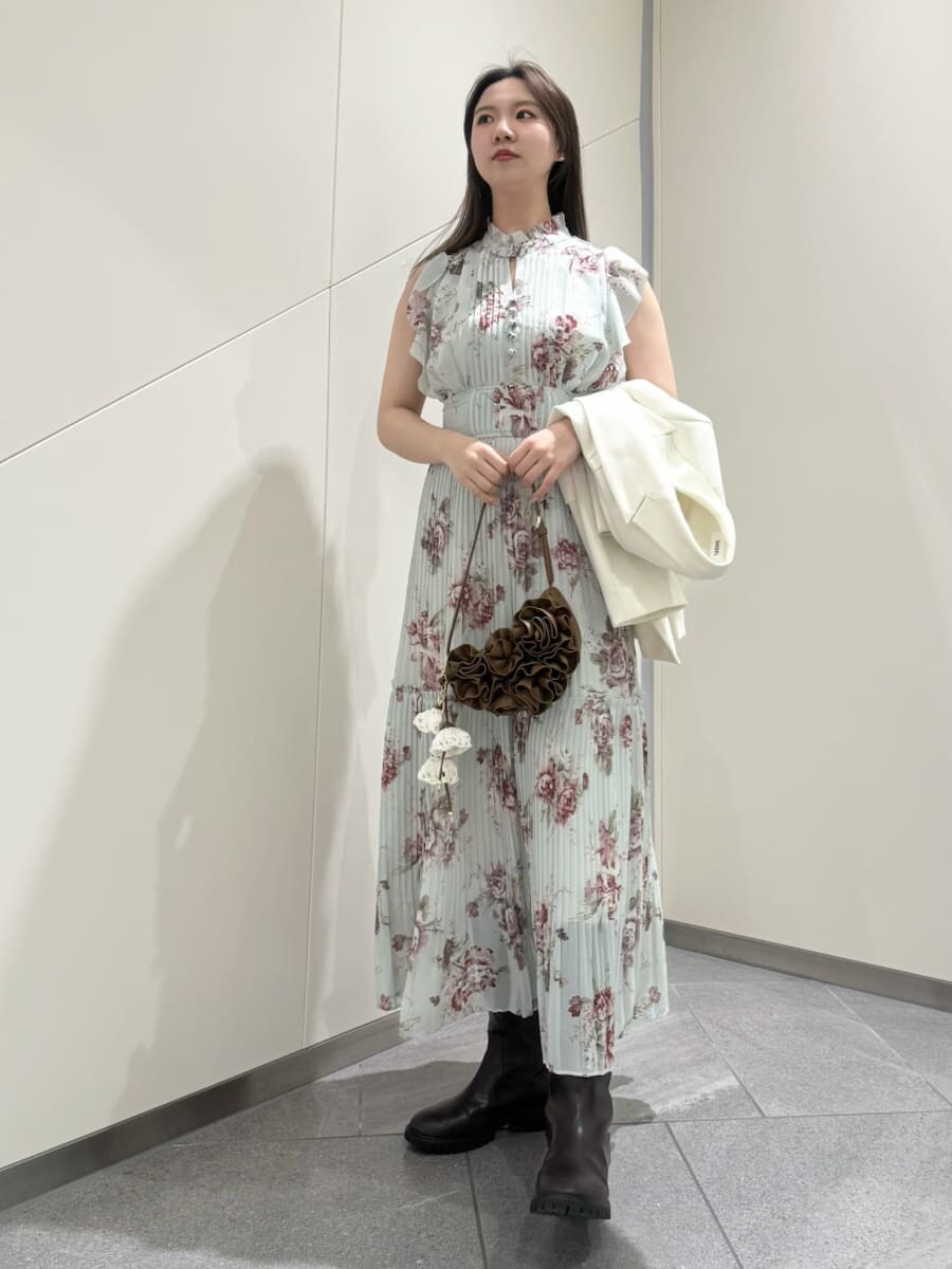 グリーン系のワンピースを着用したレディースの春コーディネートの2枚目の写真