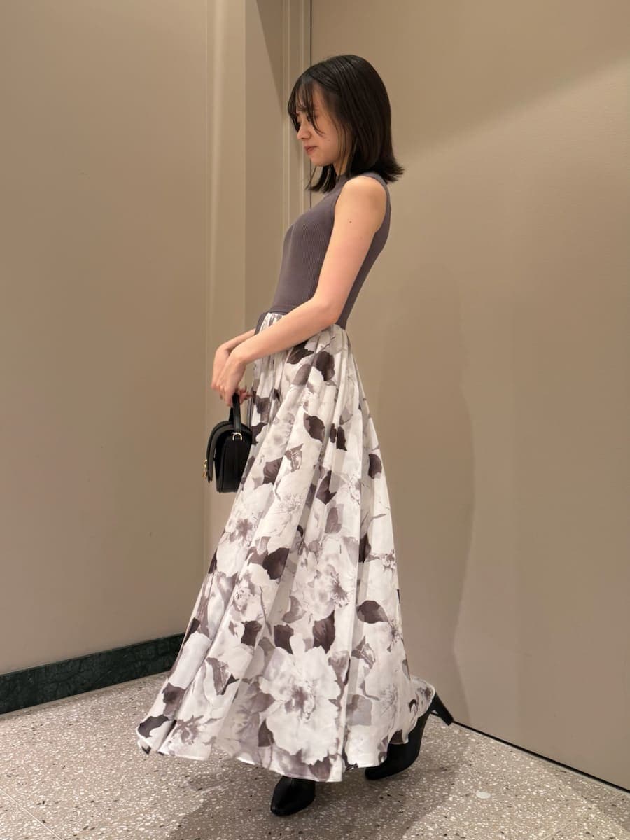 グレー系のワンピース、ブラック系のハンドバッグ、ブラック系のブーツを着用したレディースの秋コーディネートの2枚目の写真