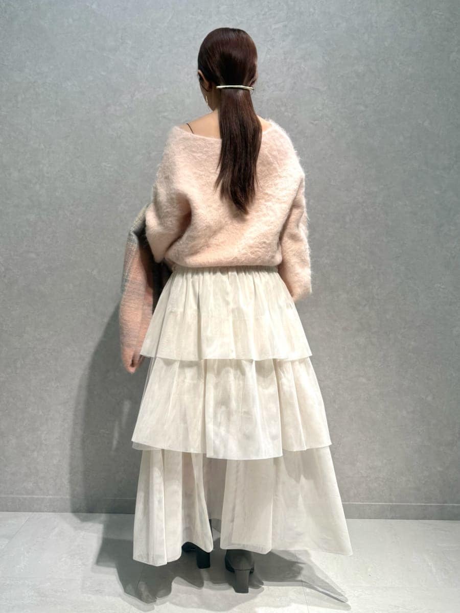 ピンク系のニット/セーター、ホワイト系のチェスターコート、ホワイト系のスカートを着用したレディースの冬コーディネートの8枚目の写真