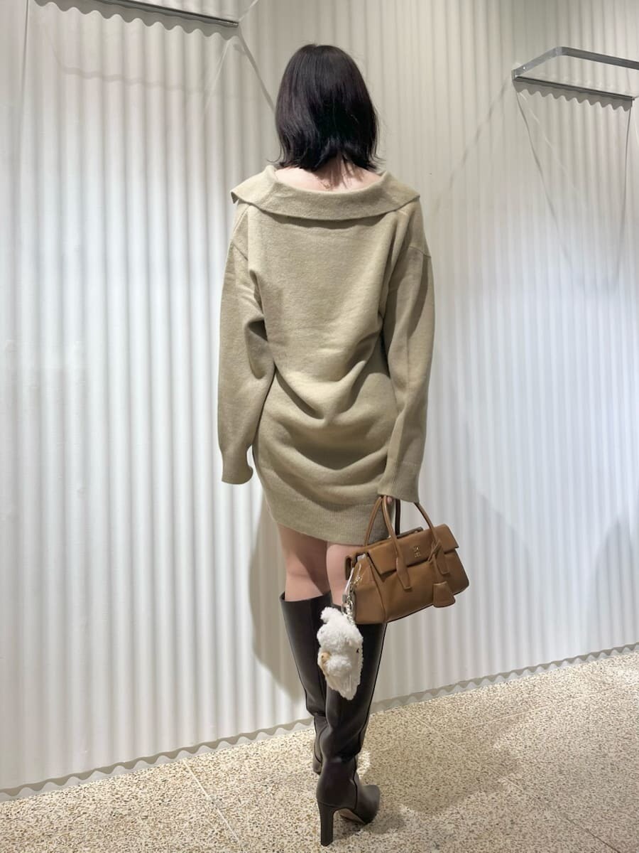 ホワイト系のダウンジャケット/コート、ブラウン系のブーツ、イエロー系のボストンバッグを着用したレディースの秋コーディネートの5枚目の写真