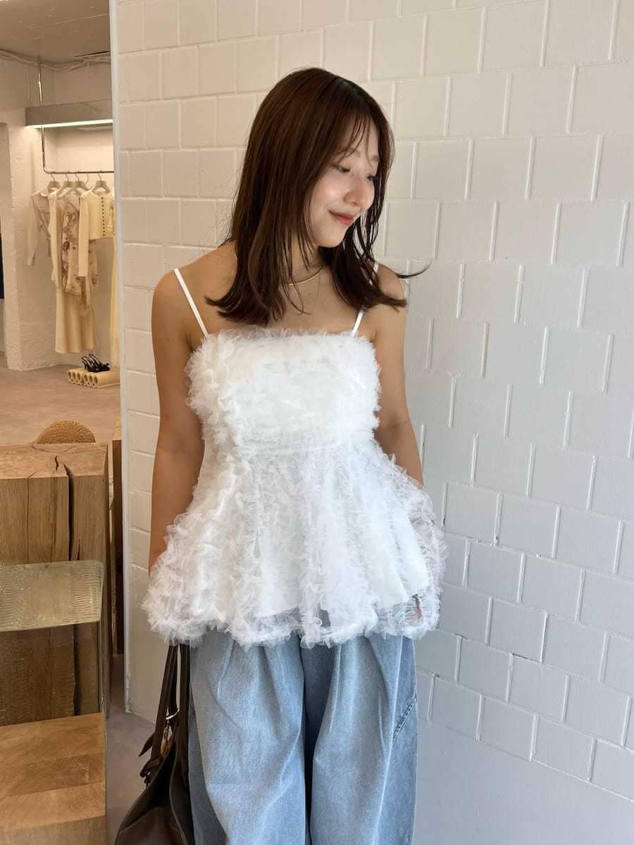 ブラック系のサンダル、ブルー系のデニムパンツ、ブラウン系のトートバッグを着用したレディースの夏コーディネートの5枚目の写真