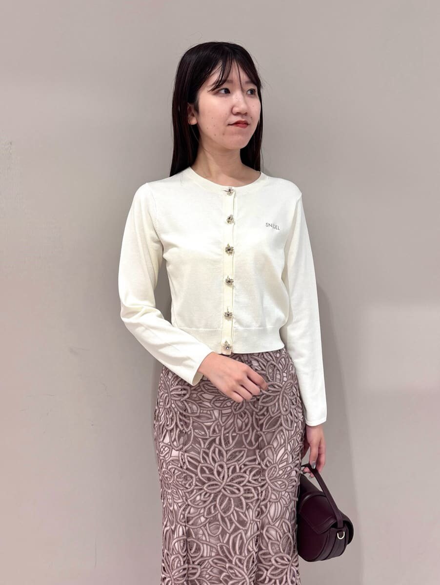 ホワイト系のカーディガン/ボレロ、ピンク系のスカート、ブラウン系のハンドバッグを着用したレディースの夏コーディネートの2枚目の写真