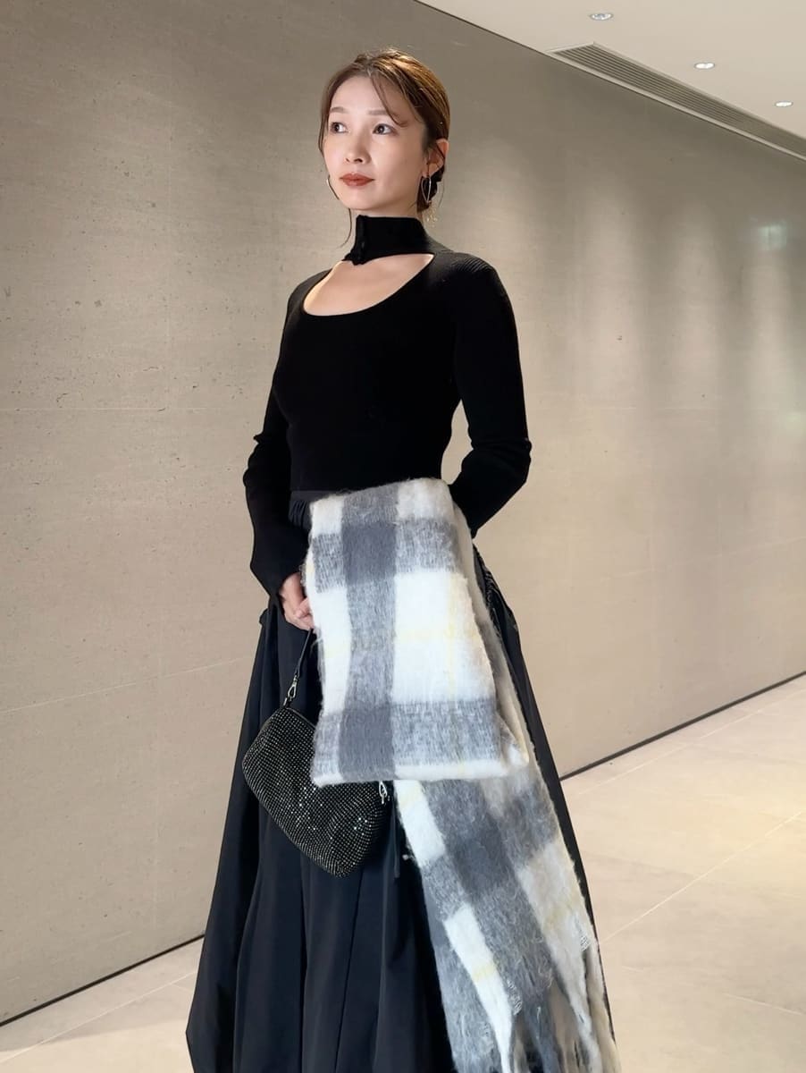 ブラック系のスカート、ブラック系のニット/セーター、グレー系のストール/ショールを着用したレディースの秋コーディネートの3枚目の写真